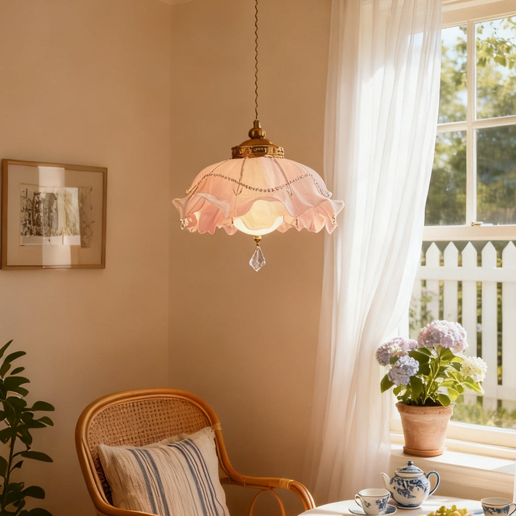 Soft pink ruffles on this Clérachic pendant, lit beside a sheer curtain with a cane chair and hydrangeas in the window.