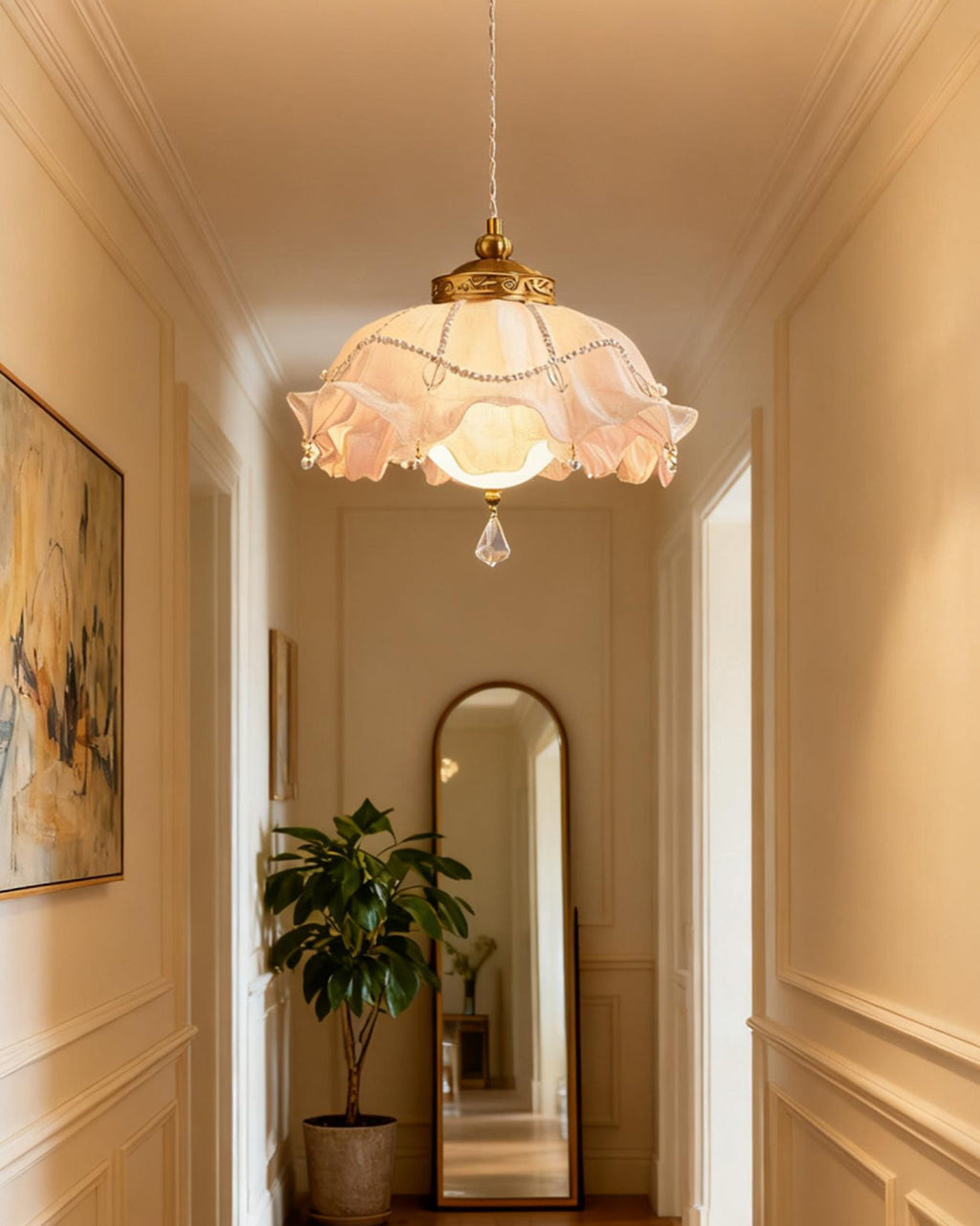 The Clérachic pendant light hanging in a cream panelled hallway, with an arched mirror and a potted plant at the far end.