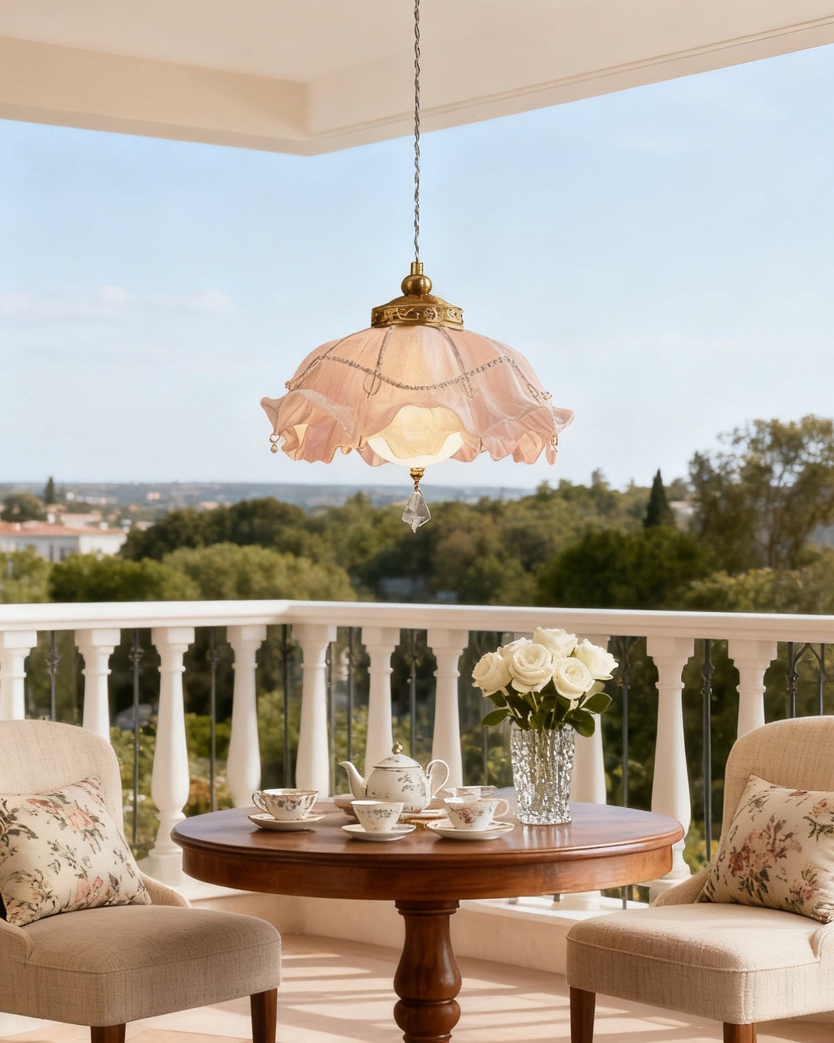 Clérachic ruffled pendant on an open terrace under a clear sky, with a white balustrade, two chairs and a tea table below.