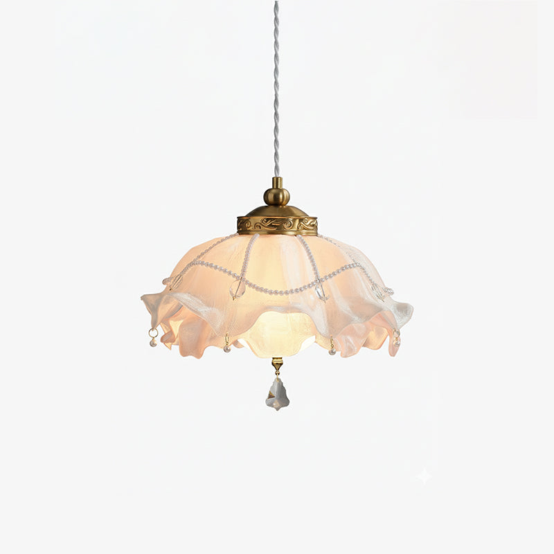 Clérachic ruffled pendant light on a plain white backdrop, lit softly, with beaded trim and a single crystal drop at the base.