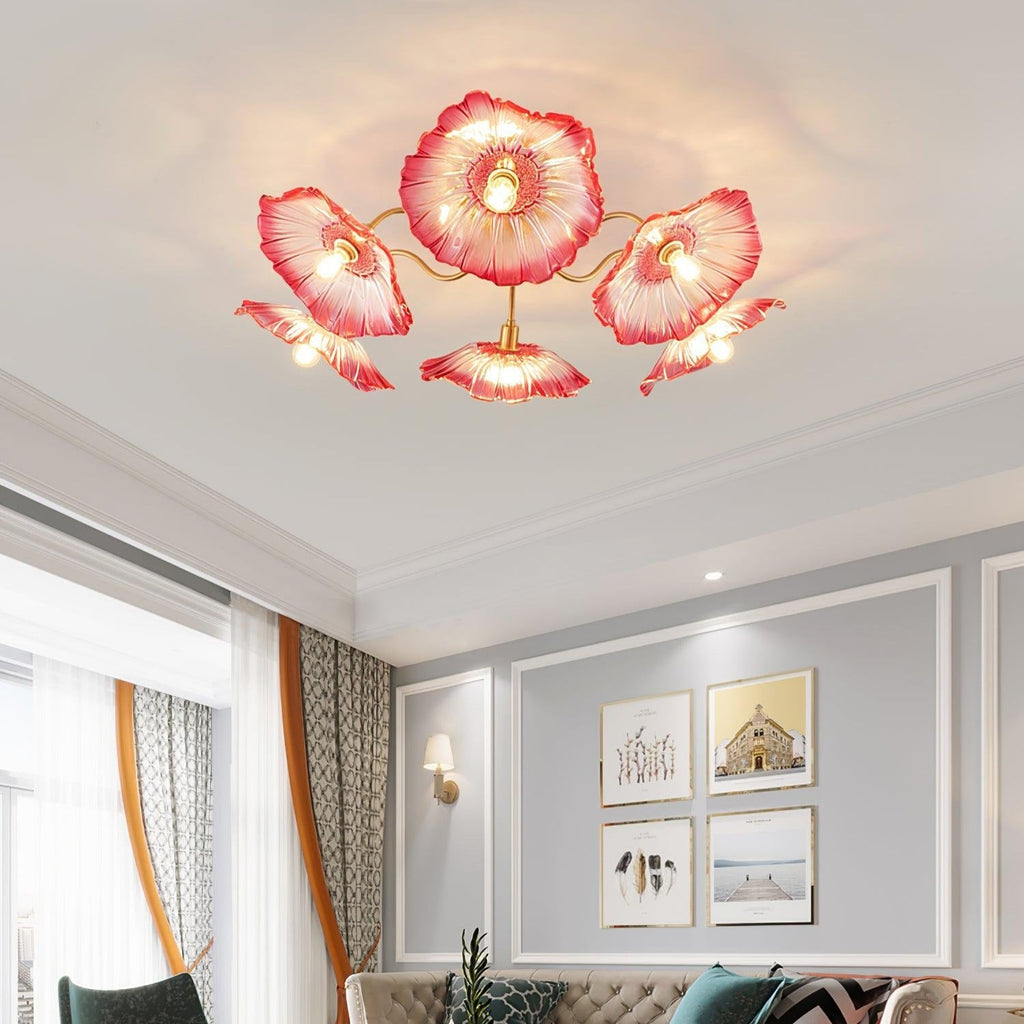 The pink glass Clérachic ceiling light lights a bedroom with a rust upholstered headboard and grey pillows.