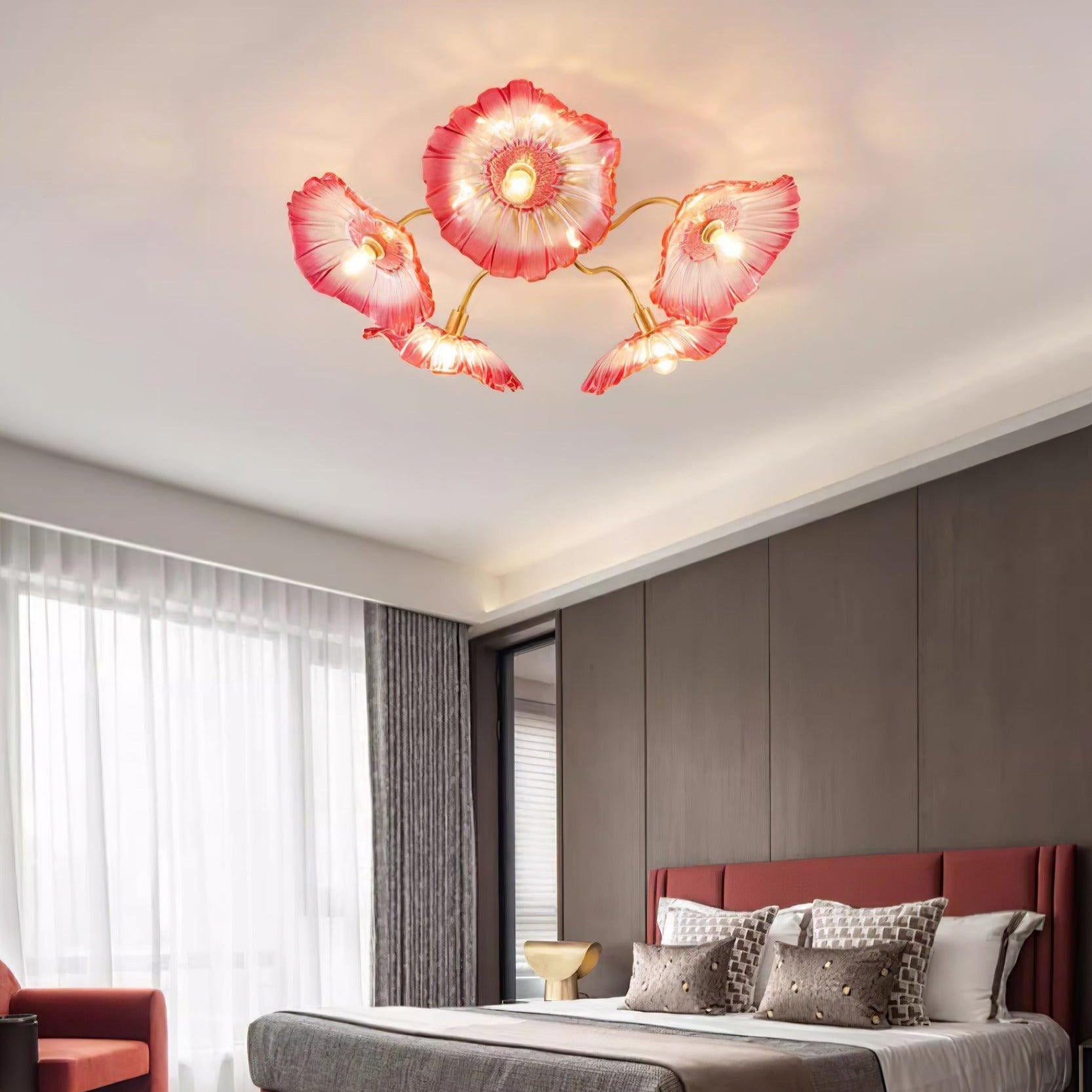 In pink glass, this Clérachic ceiling light warms a bedroom with a dark wood accent wall behind the bed.