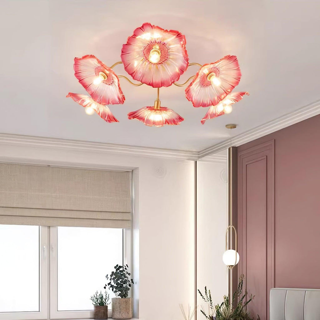 The pink glass Clérachic ceiling light sits near a rose-pink door in a room with linen roman blinds and potted plants.