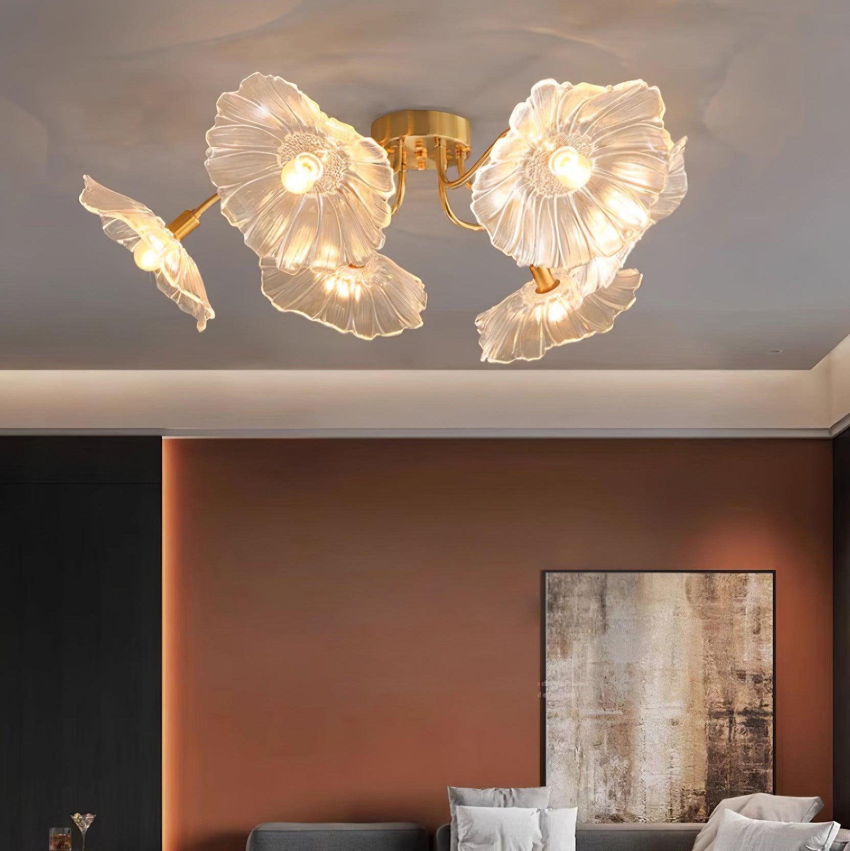Clérachic's clear glass ceiling light hangs in a living room with a terracotta accent wall and a charcoal sofa.