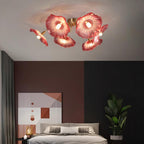 Clérachic's pink glass ceiling light warms a charcoal bedroom furnished with geometric art and a potted plant.