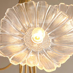 Close-up of a single clear glass flower shade on the Clérachic ceiling light, showing its ribbed petals and beaded centre.