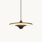 Black saucer-shaped Clérachic pendant with a brass collar, lit from beneath on a plain white backdrop.