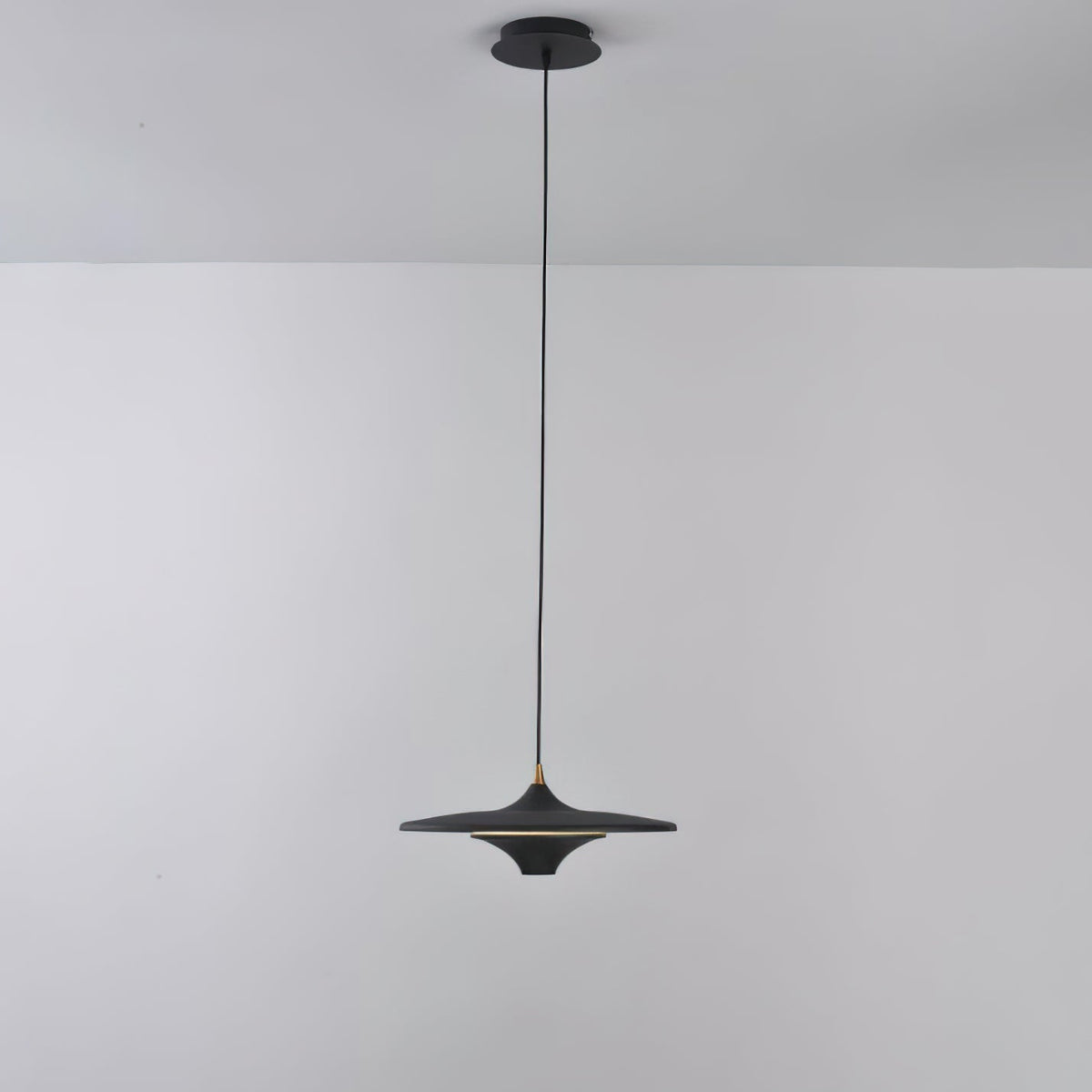 Full-length view of a black Clérachic saucer pendant on its slim black cord from a matching black ceiling canopy.