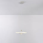 White Clérachic saucer pendant on a thin white cord from a white ceiling canopy, glowing softly against a grey wall.