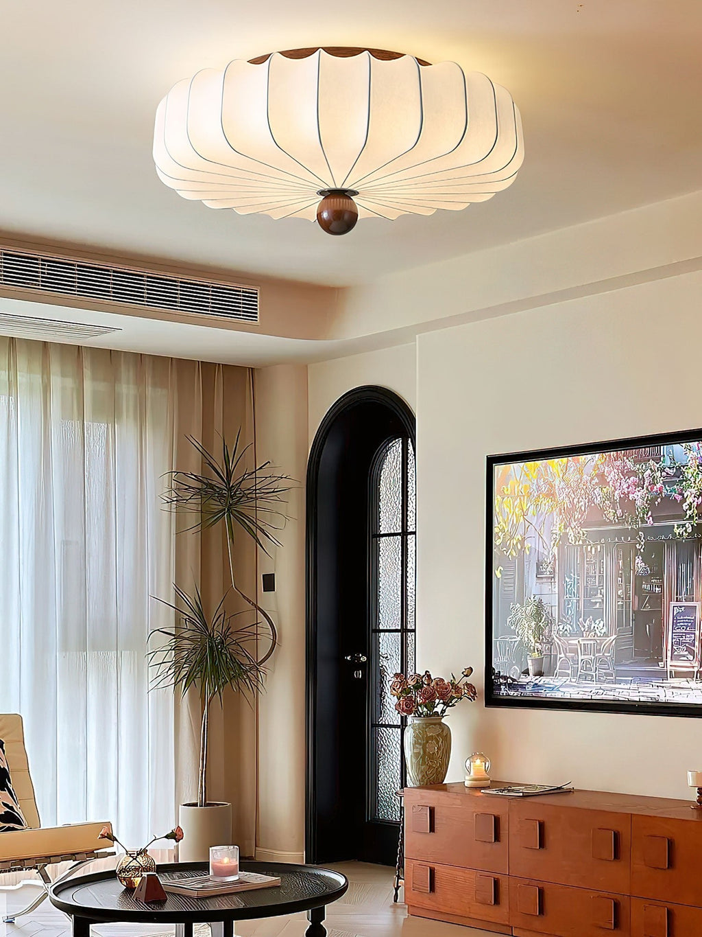Seen in a tall, narrow view, this Clérachic ceiling light sits above a living room with a low coffee table and a wooden sideboard.
