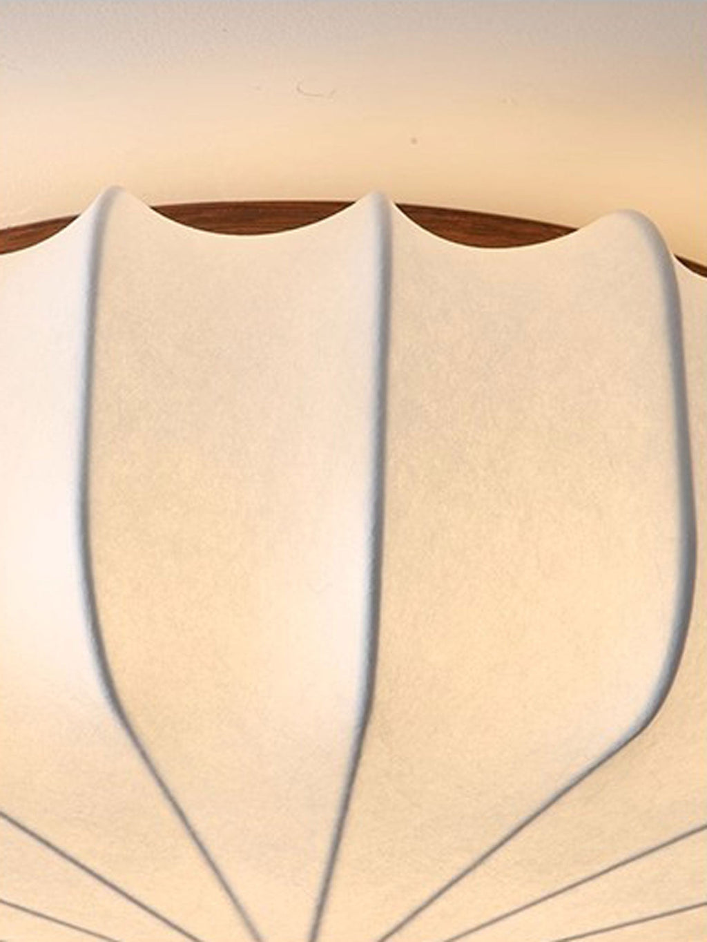 Close view of the ribbed fabric and the wooden rim on the scalloped shade of this Clérachic ceiling light.