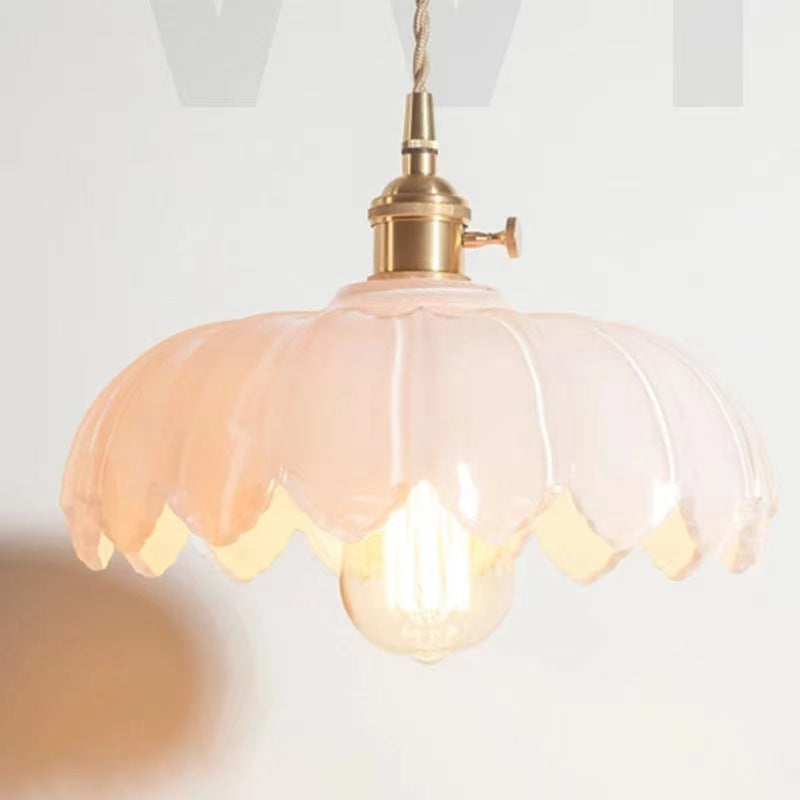The Clérachic Scalloped Flower Glass Pendant Light in milk-white opal glass, its ribbed petals glowing warm around a filament bulb.