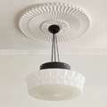 Clérachic scalloped glass dome pendant light hung on black chains beneath an ornate plaster ceiling rose in a cream panelled room