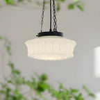 Side view of the white Clérachic scalloped glass dome pendant light, its fluted panels and round bosses framed by trailing greenery