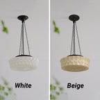 White and beige finishes of the Clérachic scalloped glass dome pendant light shown side by side, unlit, on a pale wall