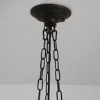Detail of the Clérachic scalloped glass dome pendant light canopy — a domed, lightly distressed bronze-black plate with three chains