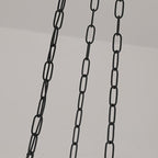 The three black suspension chains of the Clérachic scalloped glass dome pendant light dropping from a pale ceiling