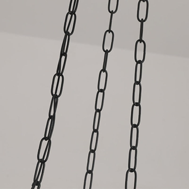The three black suspension chains of the Clérachic scalloped glass dome pendant light dropping from a pale ceiling