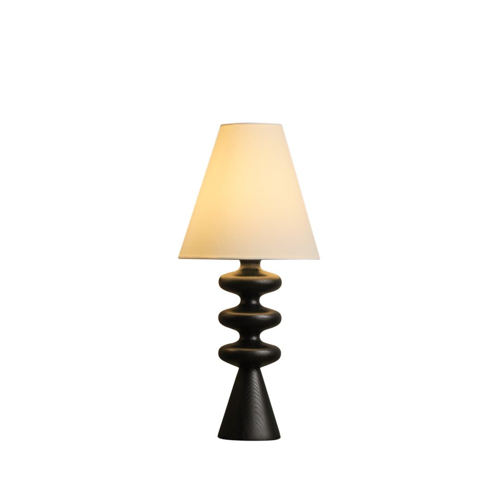 Black-based Clérachic table lamp with a lit white shade, shown whole on a plain white backdrop.