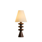 Clérachic table lamp with a black rippled stem over a dark walnut cone foot and a white shade, on a plain white backdrop.
