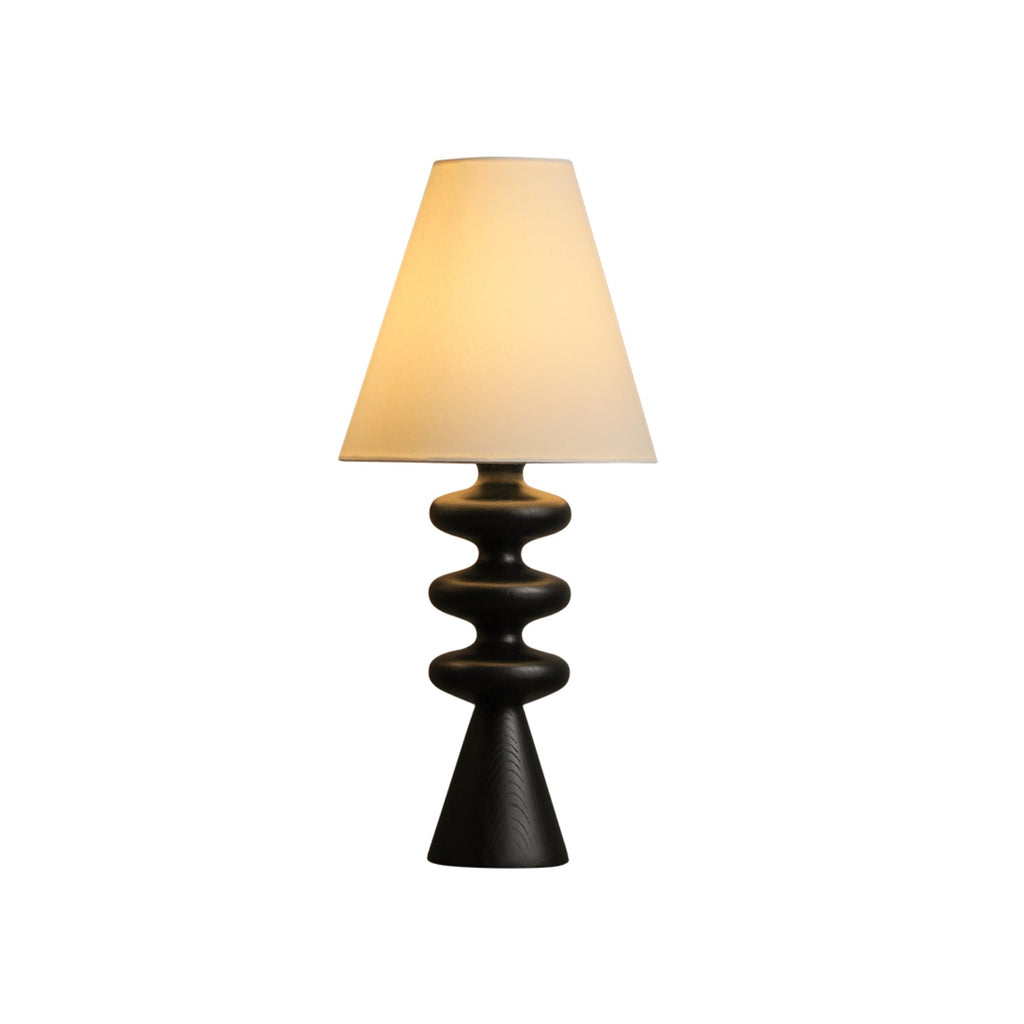 Clérachic table lamp with a black wood-grain base and a white fabric shade, shown whole on a plain white backdrop.