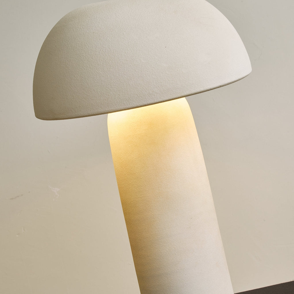 Close, tilted view of the dome and the glowing top of the column, with a fine sandy texture on the shade; a Clérachic table lamp.