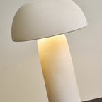 Close, tilted view of the dome and the glowing top of the column, with a fine sandy texture on the shade; a Clérachic table lamp.