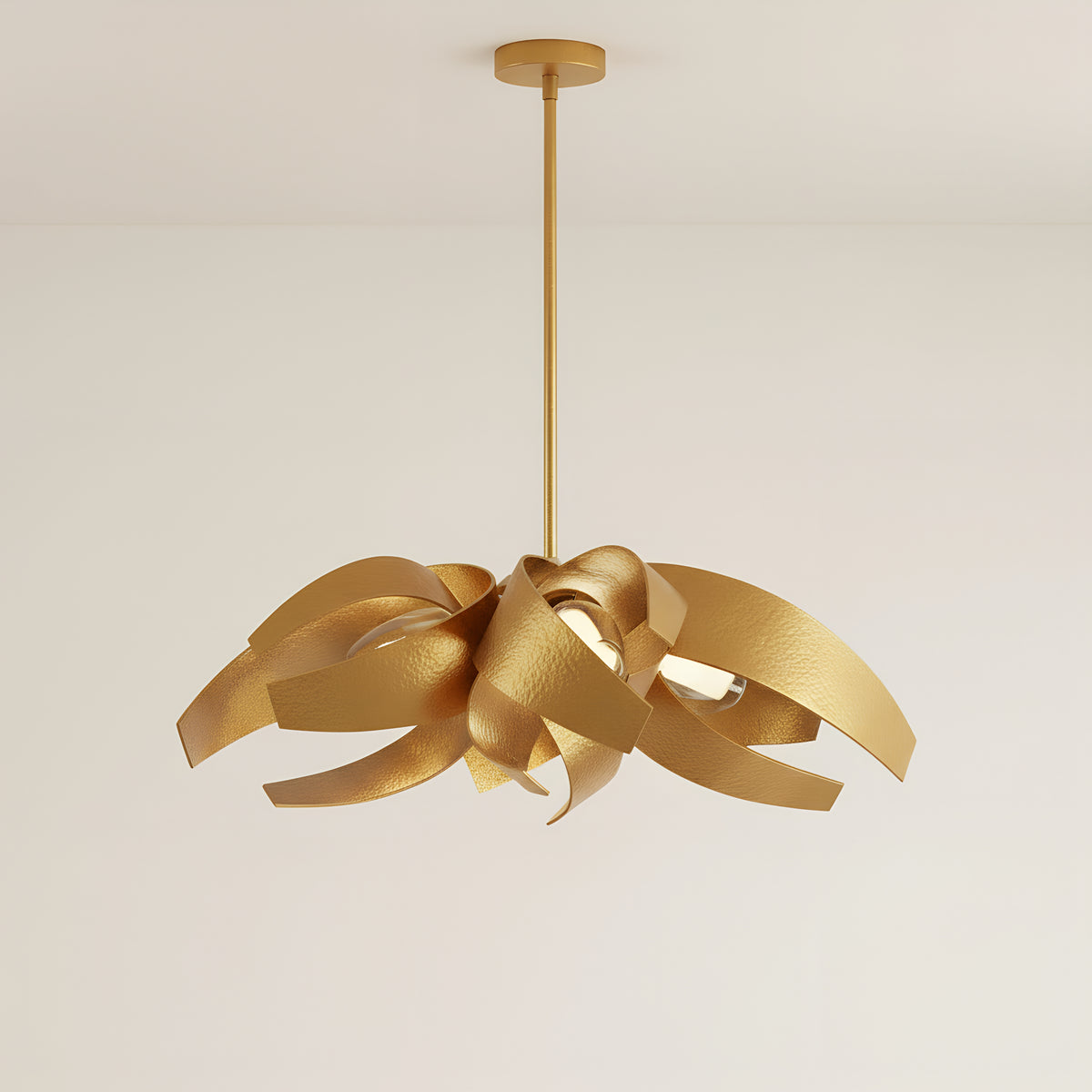 The same chandelier in the gold finish, every steel ribbon brushed gold inside and out, hanging from a single slim rod and round canopy