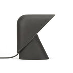 Black Clérachic table lamp on a white backdrop, with a matt finish, a folded shade over the cone base and a dark cord.
