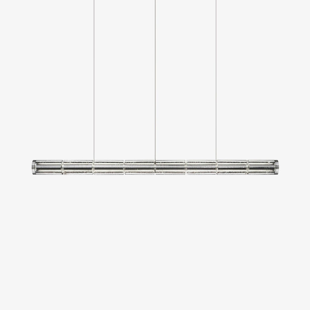 Clear segmented glass linear chandelier from Clérachic hanging on three fine cables against a plain white backdrop.