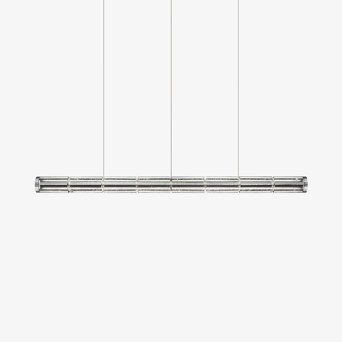 Clear segmented glass linear chandelier from Clérachic hanging on three fine cables against a plain white backdrop.