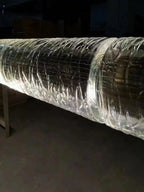 Close view of the crackled, hand-textured surface of one glass segment on this Clérachic chandelier, with a metal collar at the joint.