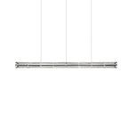 Slightly longer segmented glass linear chandelier from Clérachic with chrome end caps, hung on three cables on white.