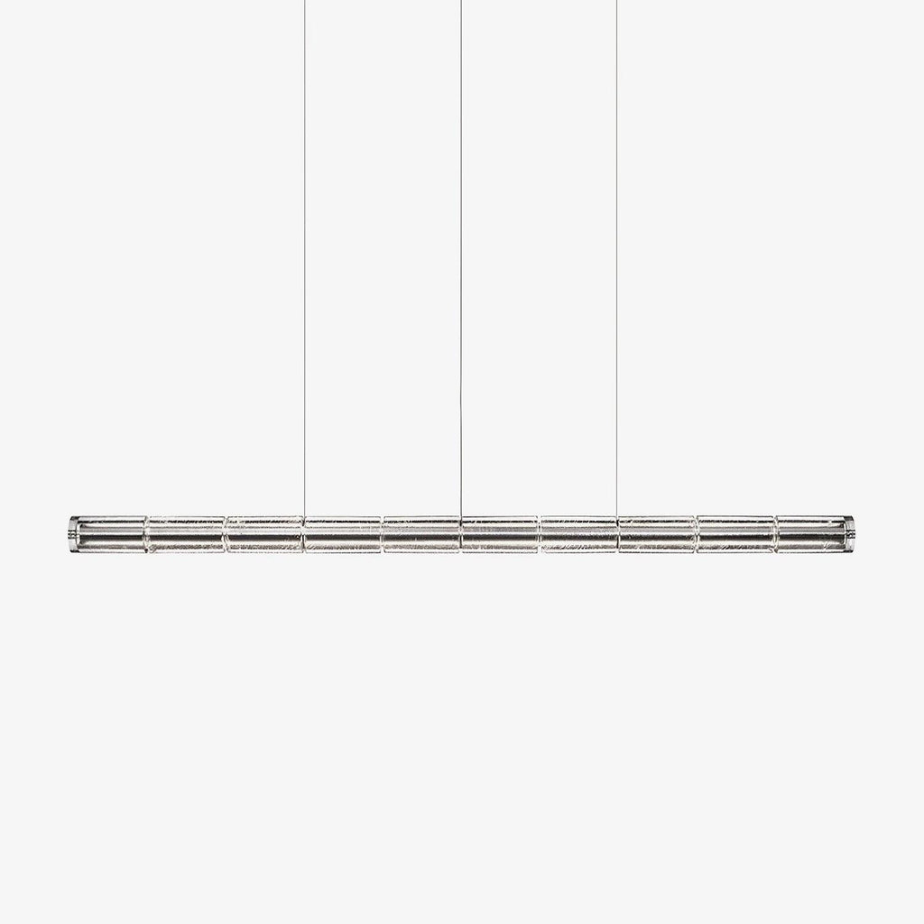 Long segmented glass chandelier from Clérachic with a chrome frame, hung on three cables against a pale grey backdrop.