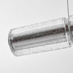 Close view of a clear crackle-textured glass segment on this Clérachic chandelier, with a chrome collar at the joint and a single cable above.