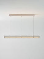 Lit Clérachic segmented glass chandelier with a soft warm glow, hung from a slim ceiling canopy against a light grey wall.
