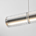 Close view of a lit glass segment of this Clérachic chandelier, the crackled clear glass glowing warm inside with a chrome collar.