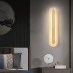 Clérachic Selvia sconce beside a bed with a round mirror and ribbed dark panelling.