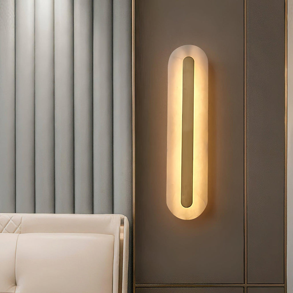 Clérachic Selvia sconce on a fluted wall beside a cream sofa and cushion.