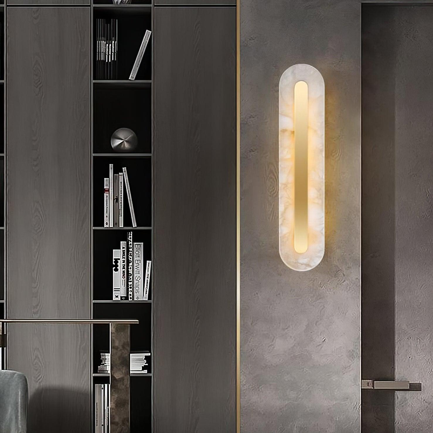 The Clérachic Selvia wall light on a concrete-effect panel beside a dark bookcase.