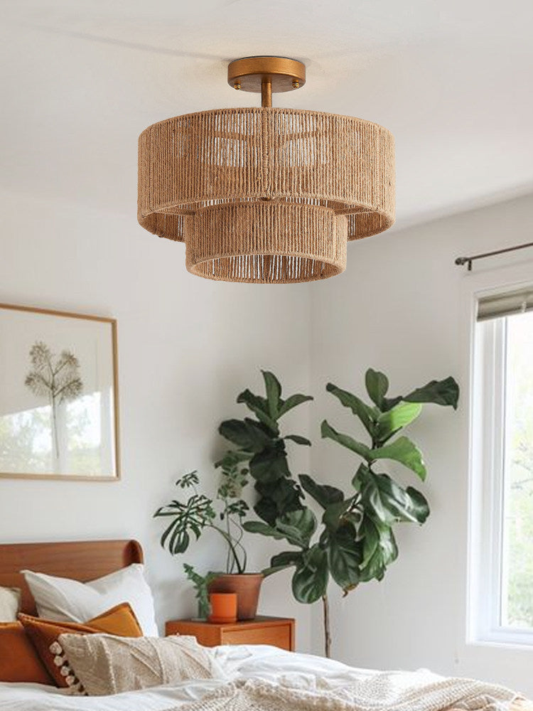 Near a fiddle-leaf fig and framed prints, this Clérachic flush-mount glows above a bedroom in gold hardware.