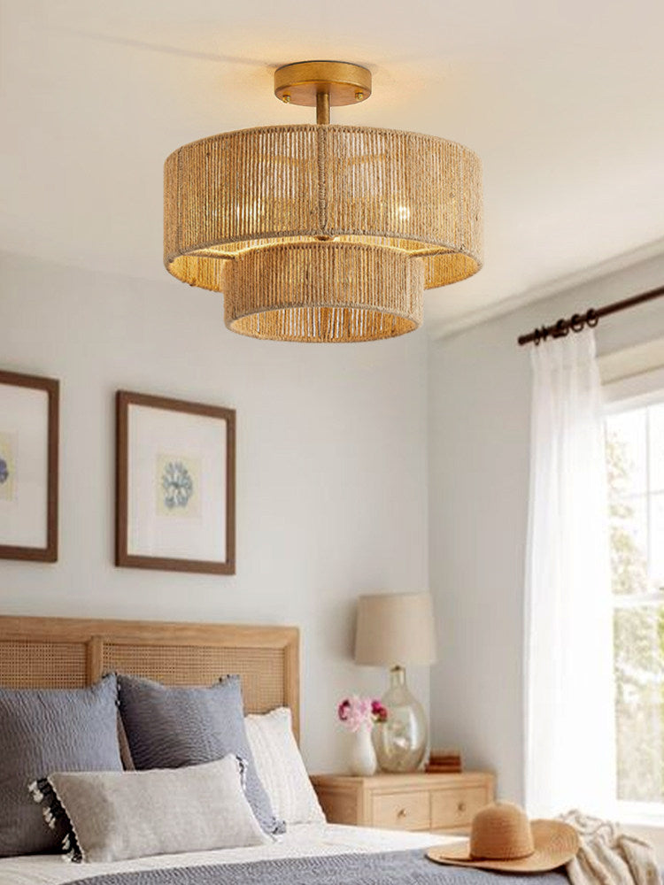 Above a gallery wall of framed art, this Clérachic ceiling light glows warm over a bedroom in gold hardware.