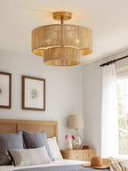 Above a gallery wall of framed art, this Clérachic ceiling light glows warm over a bedroom in gold hardware.
