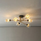 Clérachic semi-flush sputnik chandelier with six transparent globes, gold mesh inside each, lit tight against a living-room ceiling.