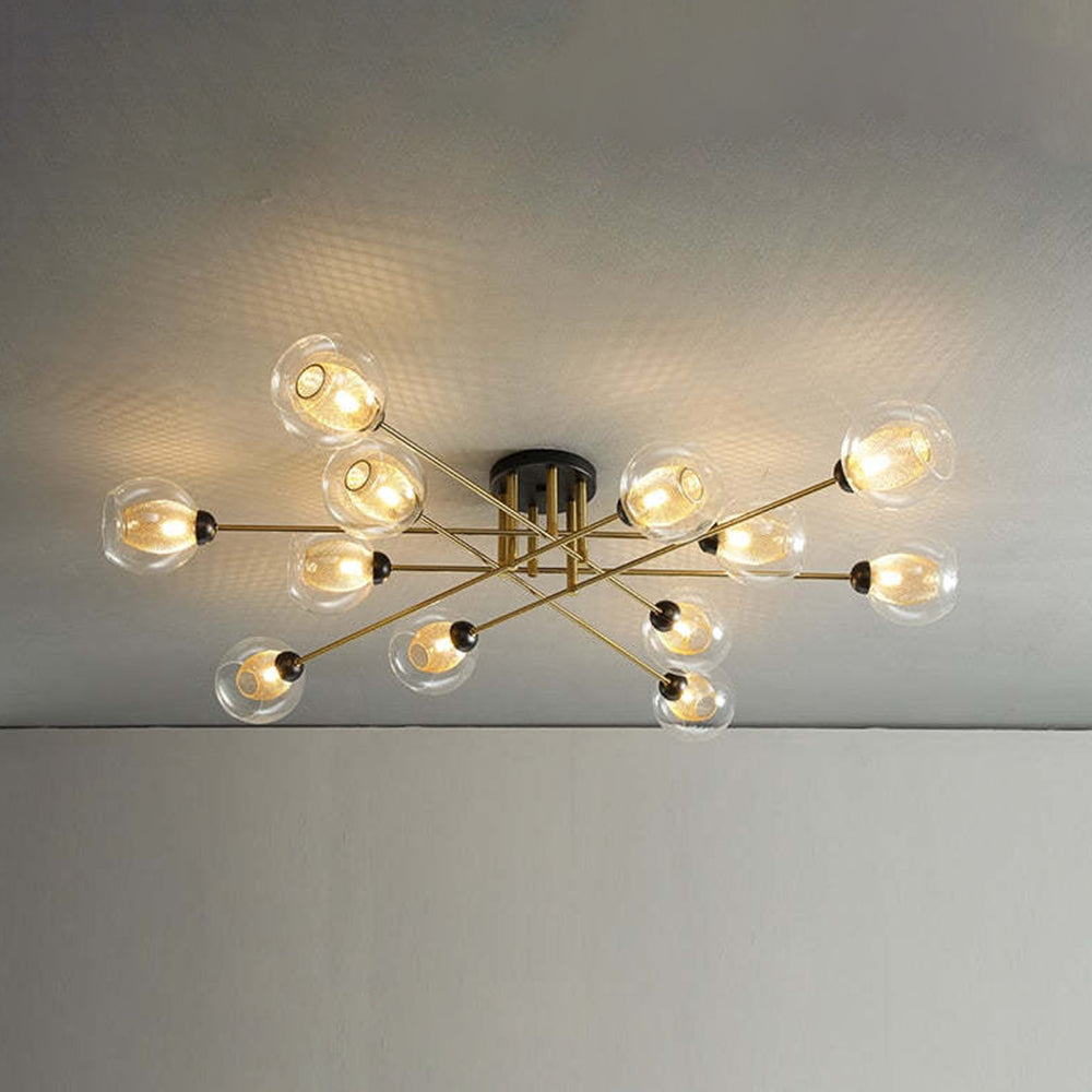 The twelve-light Clérachic sputnik chandelier fills the ceiling, transparent globes and gold mesh sleeves casting a woven pattern.