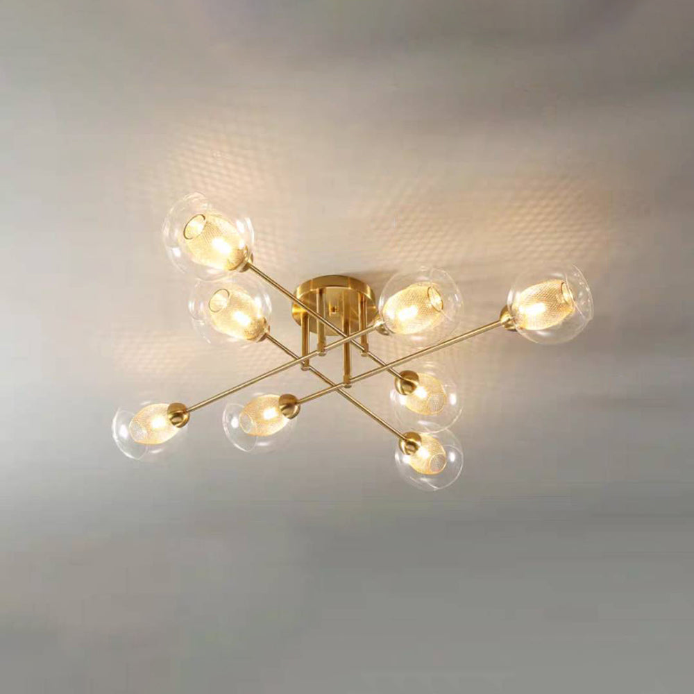 Eight transparent globes on the all-gold Clérachic sputnik chandelier, seen straight on with mesh sleeves glowing inside.