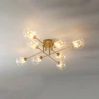 Eight transparent globes on the all-gold Clérachic sputnik chandelier, seen straight on with mesh sleeves glowing inside.