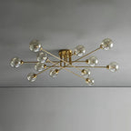 Twelve cognac globes on the gold Clérachic sputnik chandelier, spanning a plain grey ceiling at its full width.