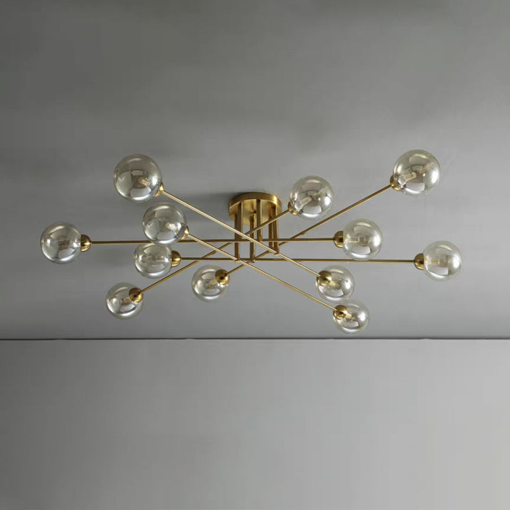 Twelve cognac globes on the gold Clérachic sputnik chandelier, spanning a plain grey ceiling at its full width.