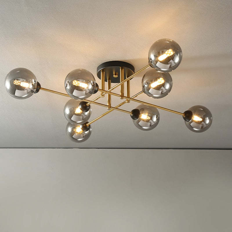 Close three-quarter view of the Clérachic sputnik chandelier, eight grey smoked globes lit on brushed-gold rods.
